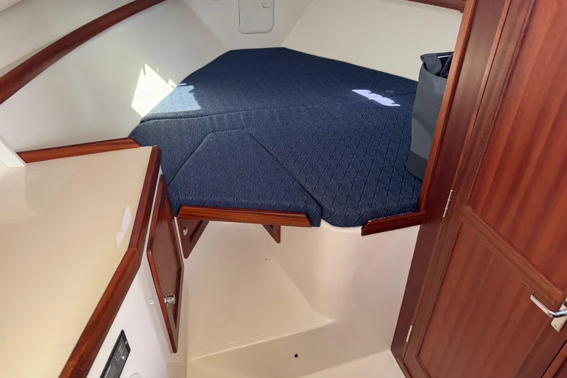 Slide: The Image of 2026 NorthCoast 285 HT cabin interior with blue cushioned bed and wooden accents. - 29