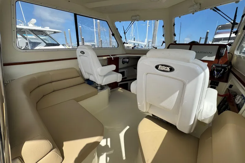 Slide: The Image of Interior of 2026 NorthCoast 285 HT boat with beige seating and helm station. - 5
