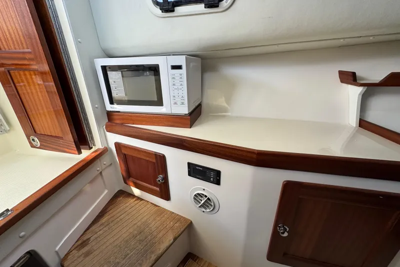 Slide: The Image of Interior of 2026 NorthCoast 285 HT boat with microwave and wooden cabinetry. - 9
