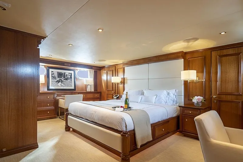 Slide: The Image of Luxurious bedroom interior on 2000 Broward Raised Pilothouse yacht with elegant wood paneling. - 10