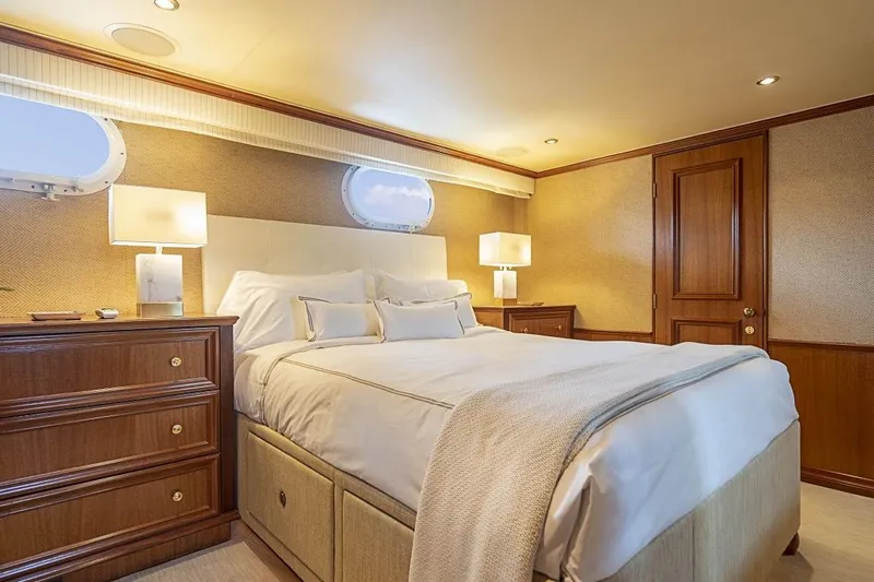 Slide: The Image of Luxurious bedroom interior on 2000 Broward Raised Pilothouse yacht, featuring elegant wood furnishings. - 14