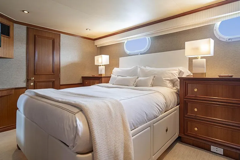 Slide: The Image of Luxurious bedroom interior on 2000 Broward Raised Pilothouse yacht, featuring elegant wood furnishings. - 17