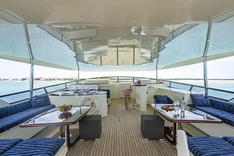 Slide: The Image of Luxurious 2000 Broward Raised Pilothouse yacht deck with elegant seating and dining area. - 20