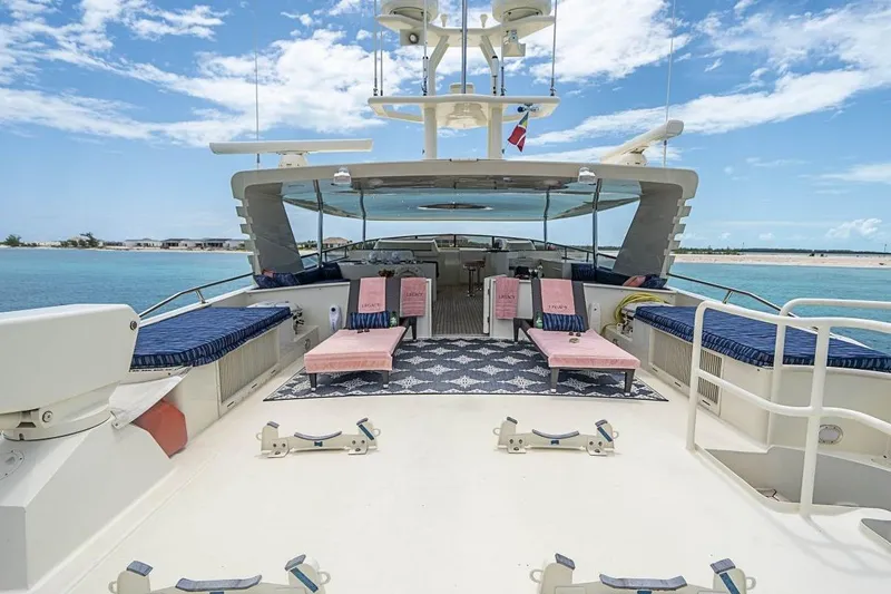 Slide: The Image of Luxurious 2000 Broward Raised Pilothouse yacht deck with seating, ocean view, and clear skies. - 25