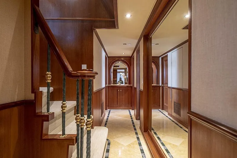 Slide: The Image of Luxurious interior of 2000 Broward Raised Pilothouse yacht with elegant wood paneling and staircase. - 9