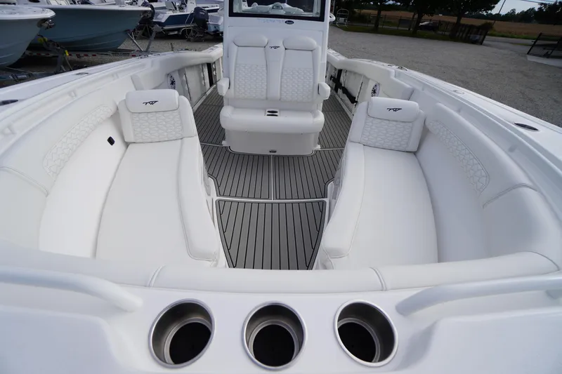 Slide: The Image of 2026 Tidewater 282 CC Adventure boat interior with white seating and cup holders. - 12