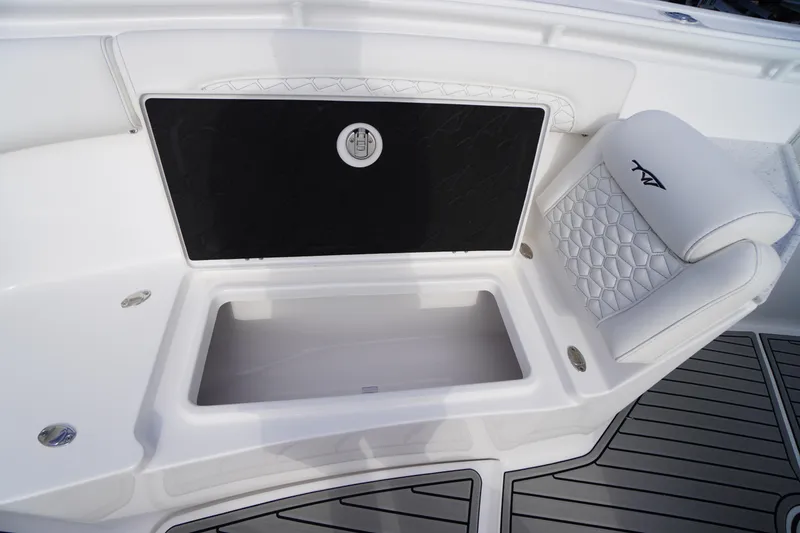 Slide: The Image of 2026 Tidewater 282 CC Adventure boat with open storage compartment and cushioned seating. - 18