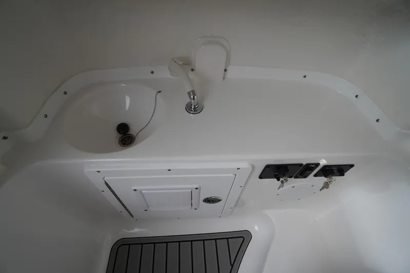 Slide: The Image of Interior view of 2026 Tidewater 282 CC Adventure boat featuring a compact sink and storage area. - 27