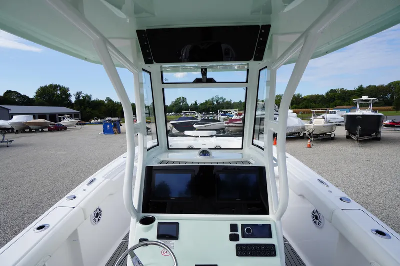 Slide: The Image of 2026 Tidewater 282 CC Adventure boat dashboard with dual screens, parked in a marina. - 33