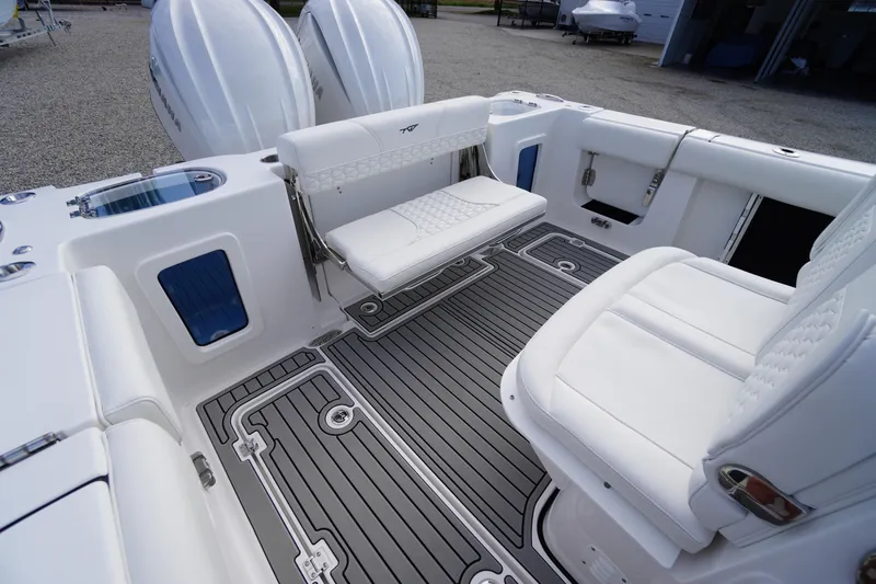 Slide: The Image of 2026 Tidewater 282 CC Adventure boat interior with white seating and dual engines. - 69
