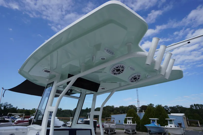 Slide: The Image of 2026 Tidewater 282 CC Adventure boat with T-top and rod holders under a blue sky. - 82