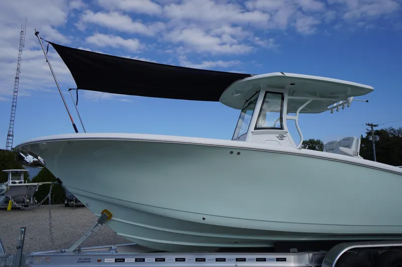 Slide: The Image of 2026 Tidewater 282 CC Adventure boat on trailer under blue sky. - 97