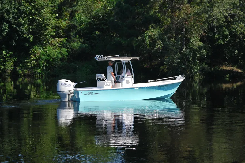 The Image of 2021 May-Craft 23 Cape Classic boat on calm water, surrounded by lush greenery. - 0