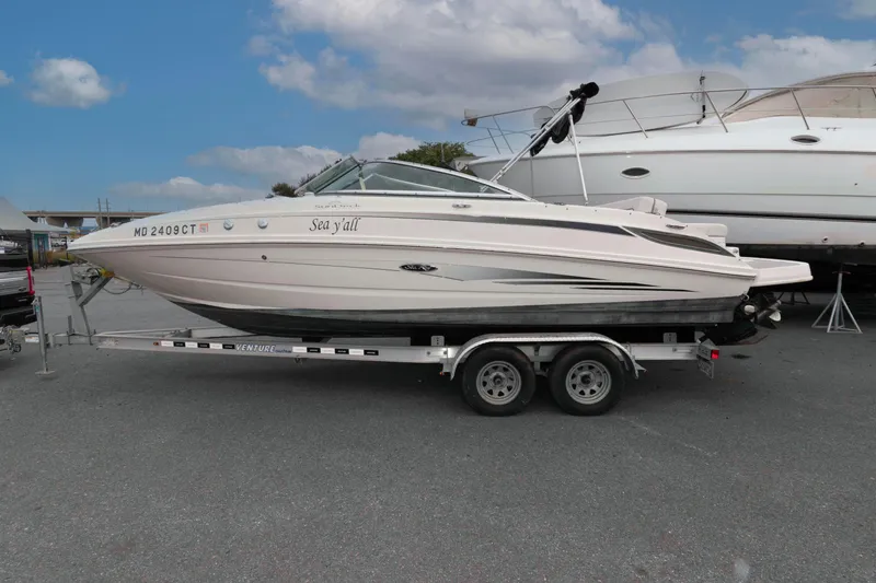 The Image of 2010 Sea Ray 240 Sundeck boat on trailer under a cloudy sky. - 0