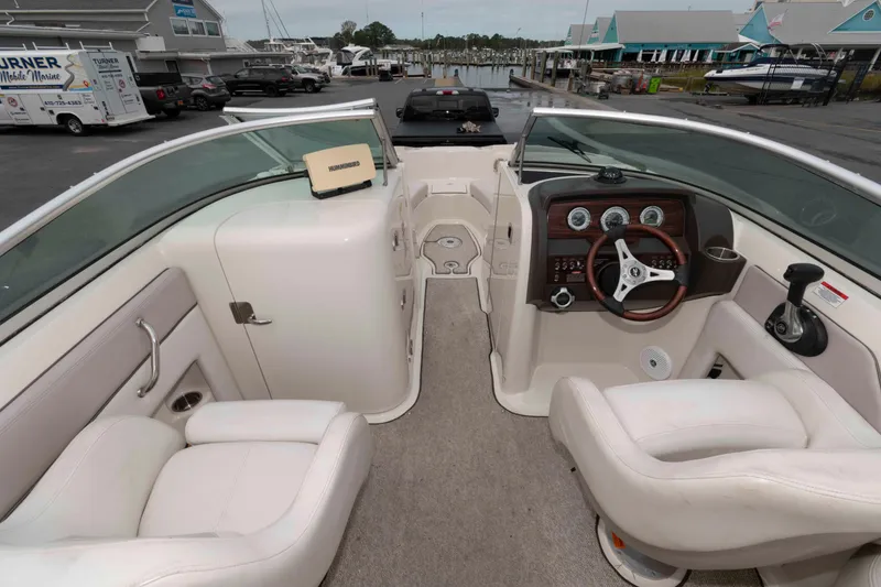 Slide: The Image of 2010 Sea Ray 240 Sundeck interior with white seating and dashboard controls. - 4