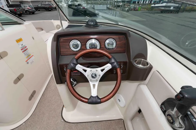 Slide: The Image of 2010 Sea Ray 240 Sundeck dashboard with wood accents and steering wheel. - 6
