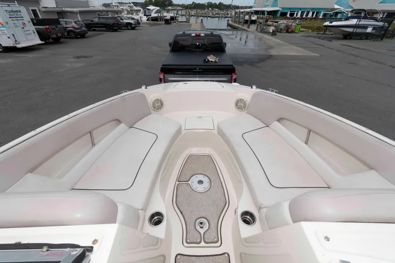 Slide: The Image of 2010 Sea Ray 240 Sundeck interior with spacious seating, docked at a marina. - 7