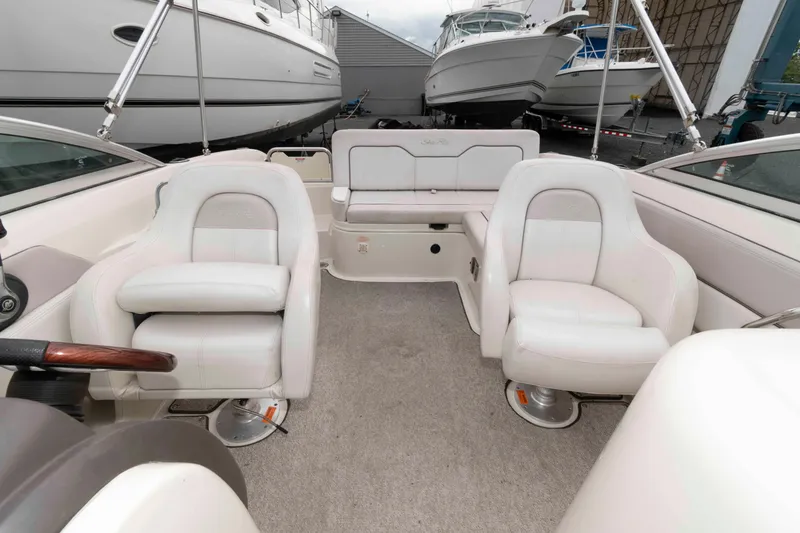 Slide: The Image of Interior of 2010 Sea Ray 240 Sundeck boat with white seating and carpeted floor. - 8