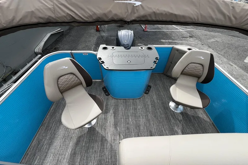 Slide: The Image of 2026 Bennington S22 boat interior with blue paneling and beige seating. - 14