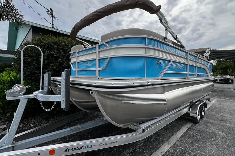 Slide: The Image of 2026 Bennington S22 pontoon boat on trailer, featuring blue and silver design. - 3