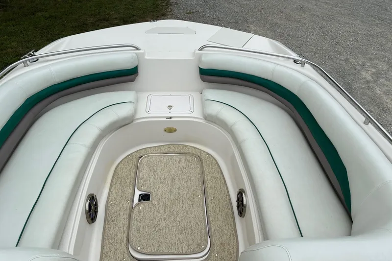 Slide: The Image of 2003 Hurricane 234 SD boat interior with white and green seating, carpeted floor, and storage compartment. - 5