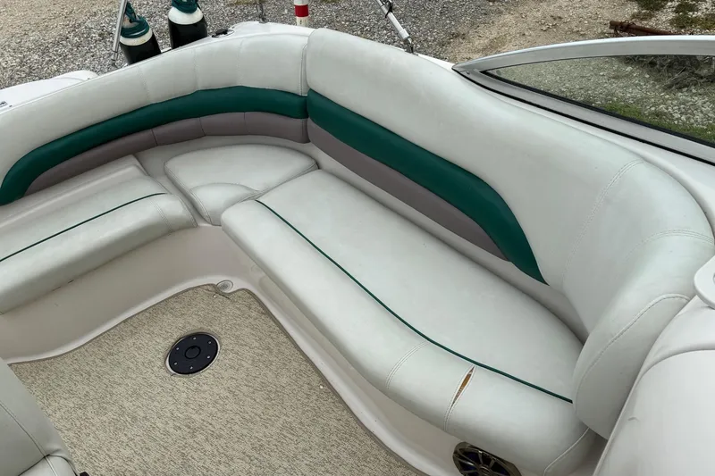 Slide: The Image of 2003 Hurricane 234 SD boat interior with white and green seating, beige carpet. - 9