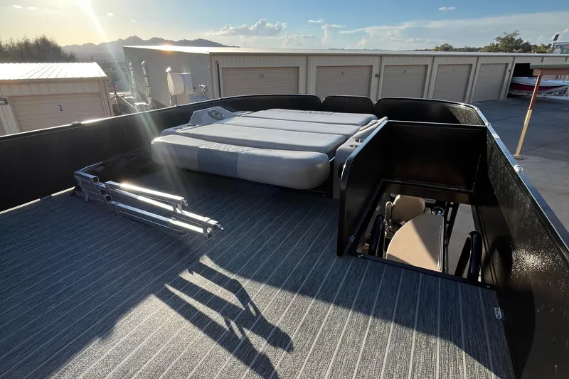 Slide: The Image of 2023 Premier 310 Boundary Waters Revolution Top Deck with seating and storage, in a sunny outdoor setting. - 15