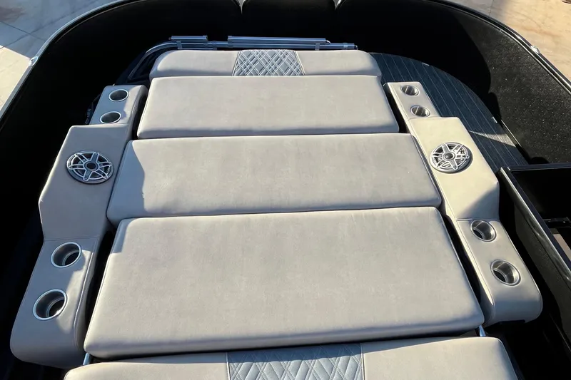 Slide: The Image of 2023 Premier 310 Boundary Waters Revolution Top Deck with cushioned seating and integrated speakers. - 16