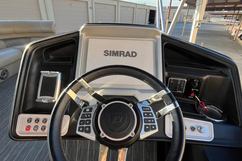 Slide: The Image of Steering console of 2023 Premier 310 Boundary Waters Revolution Top Deck with Simrad display. - 19