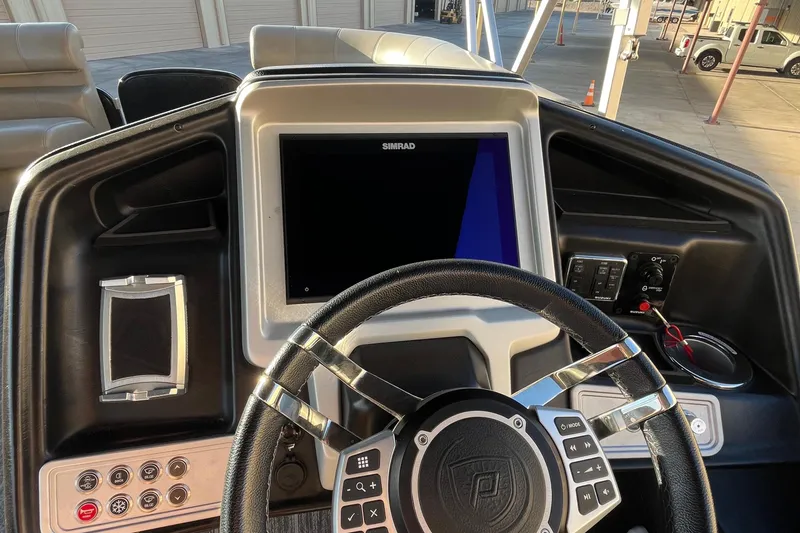 Slide: The Image of 2023 Premier 310 Boundary Waters Revolution Top Deck boat dashboard with steering wheel and controls. - 6