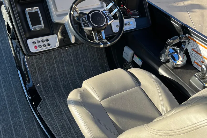Slide: The Image of 2023 Premier 310 Boundary Waters Revolution Top Deck boat interior with steering wheel and controls. - 9
