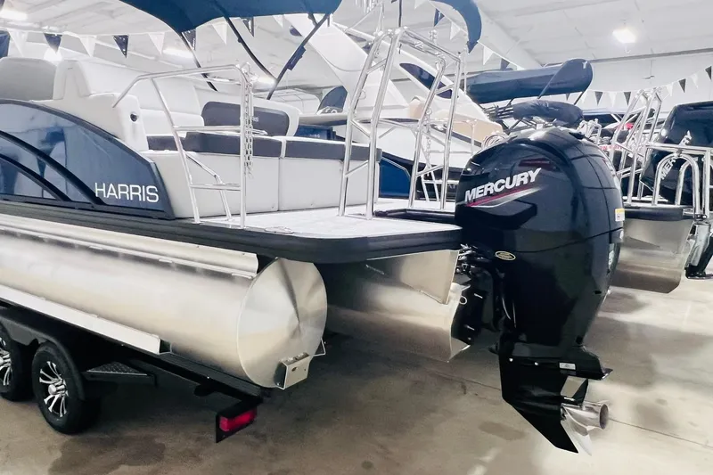 Slide: The Image of 2025 Harris Cruiser 230 Heritage Edition pontoon boat with Mercury outboard motor in showroom. - 16