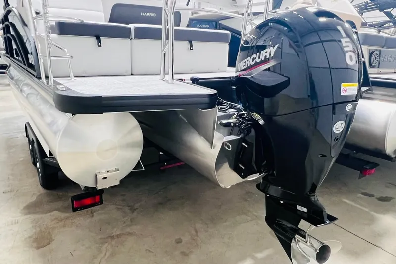 Slide: The Image of 2025 Harris Cruiser 230 Heritage Edition with Mercury 150 outboard motor, rear view. - 18