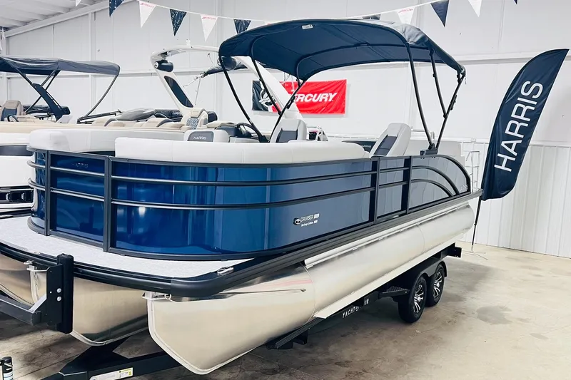 The Image of 2025 Harris Cruiser 230 Heritage Edition pontoon boat in showroom display. - 0