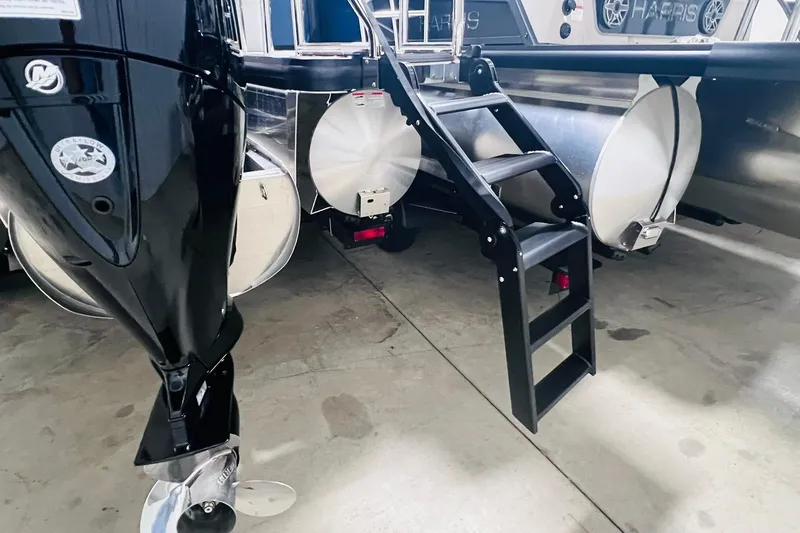 Slide: The Image of 2025 Harris Cruiser 230 Heritage Edition boat with ladder and motor detail. - 22