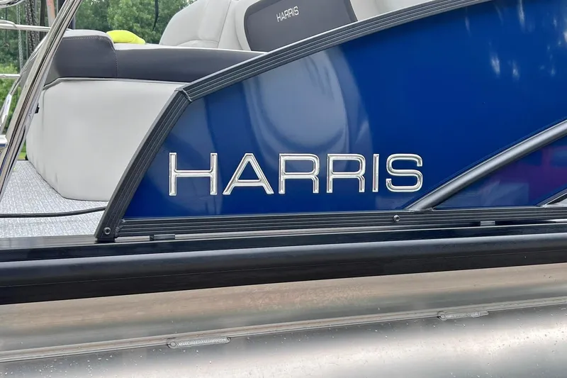 Slide: The Image of 2025 Harris Cruiser 230 Heritage Edition boat, blue panel with logo. - 23