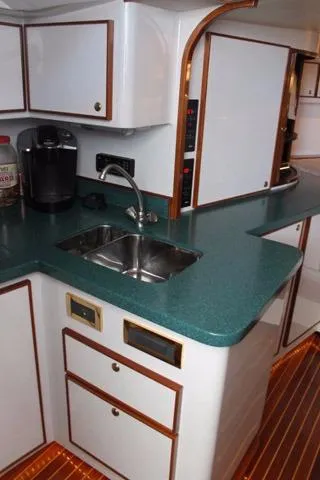 Slide: The Image of 2005 Custom DeSanti Carolina Express boat kitchen with green countertop and stainless steel sink. - 10