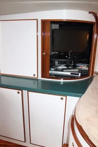 Slide: The Image of 2005 Custom DeSanti Carolina Express interior with TV and storage cabinets. - 11