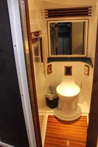 Slide: The Image of Compact bathroom in 2005 Custom DeSanti Carolina Express boat with wooden flooring. - 12