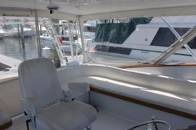 Slide: The Image of Interior of 2005 Custom DeSanti Carolina Express boat with white seating and marina view. - 20