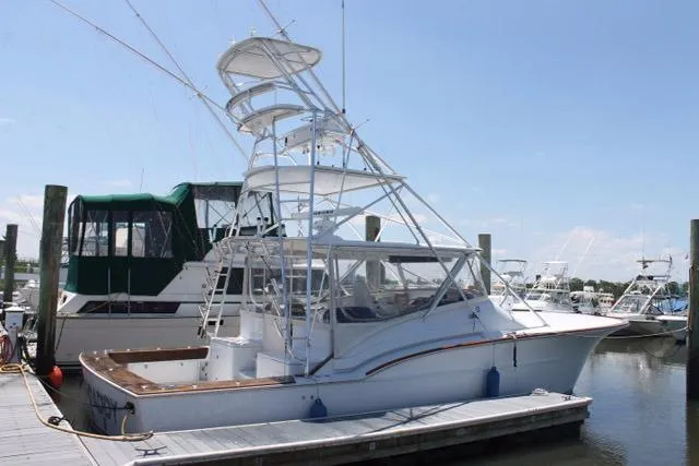 Slide: The Image of 2005 Custom DeSanti Carolina Express boat docked at marina under clear sky. - 21