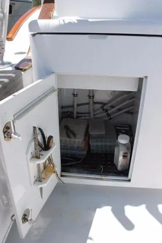 Slide: The Image of Open storage compartment on 2005 DeSanti Carolina Express boat showing interior equipment and supplies. - 23