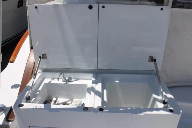 Slide: The Image of 2005 Custom DeSanti Carolina Express boat sink and storage area with open lids. - 26
