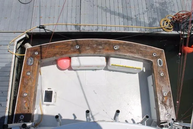 Slide: The Image of 2005 Custom DeSanti Carolina Express boat docked, featuring a wooden deck and fishing rod holders. - 28