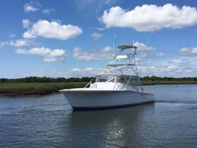 Slide: The Image of 2005 Custom DeSanti Carolina Express boat on calm water under blue sky. - 4