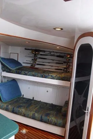 Slide: The Image of Interior of 2005 Custom DeSanti Carolina Express with bunk beds and fishing rods. - 7