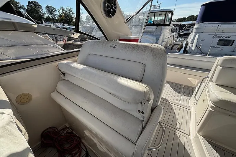 Slide: The Image of 2005 Regal Commodore 4260 boat interior with white seating and marina view. - 12