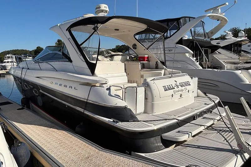 Slide: The Image of 2005 Regal Commodore 4260 yacht docked at marina under clear blue sky. - 2
