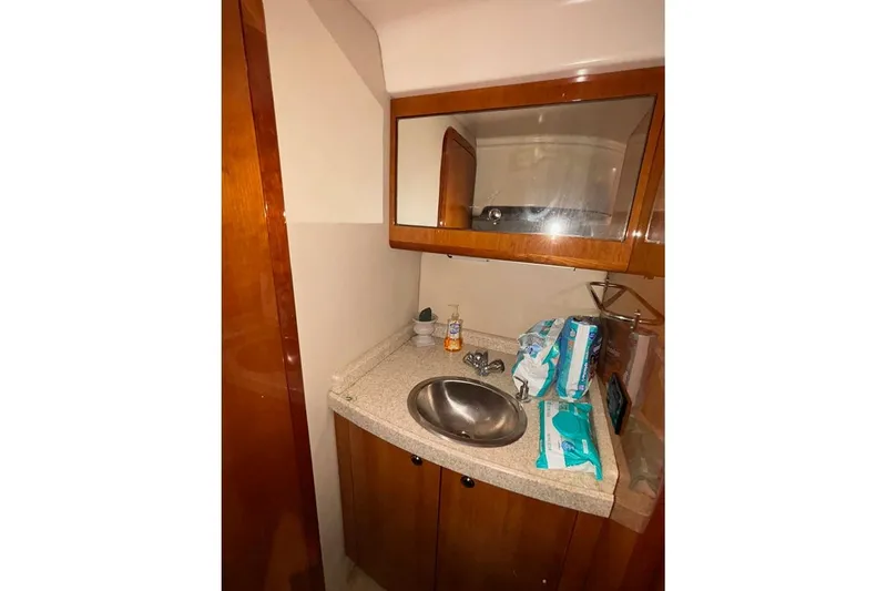 Slide: The Image of 2005 Regal Commodore 4260 yacht bathroom with sink, mirror, and toiletries. - 26