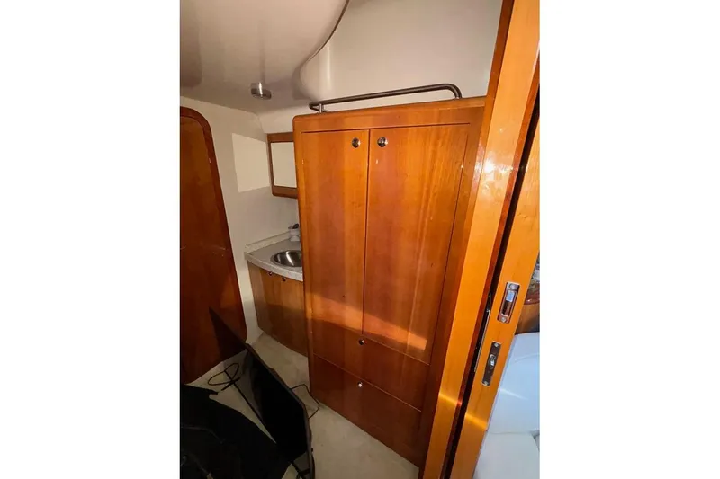 Slide: The Image of 2005 Regal Commodore 4260 yacht interior with wooden cabinetry and compact sink area. - 27